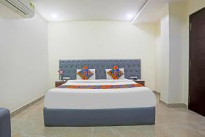 une chambre avec un grand lit dans une pièce dans l'établissement FabHotel RR Residency I - Nr Khammam Bus Stand, à Khammam