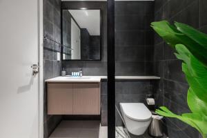 a bathroom with a sink and a toilet and a mirror at Sahab - Hermes Leather Home in Sharjah