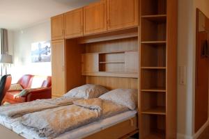 a bedroom with a bed with wooden shelves at Inselblume 55 - Ferienwohnung in der Strandburg mit Hund in Burgtiefe auf Fehmarn 
