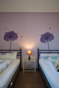 two beds in a room with purple walls at Inselblume 22 - Ferienhaus mit Garten und Hund in Landkirchen in Landkirchen