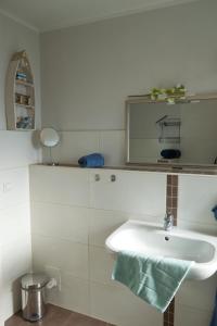 a white bathroom with a sink and a mirror at Inselblume 22 - Ferienhaus mit Garten und Hund in Landkirchen in Landkirchen +30 photos