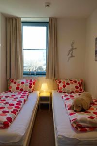 a bedroom with two beds with a teddy bear on them at Inselblume 50 - Ferienwohnung von privat in der Strandburg in Burgtiefe auf Fehmarn 