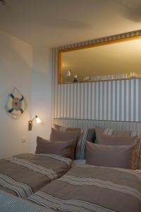 une chambre avec deux lits et un grand miroir dans l'établissement Inselblume 24 - Exklusive Ferienwohnung in der Strandburg, à Burgtiefe auf Fehmarn 