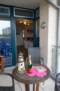- une table avec une bouteille de vin sur la terrasse dans l'établissement Inselblume 24 - Exklusive Ferienwohnung in der Strandburg, à Burgtiefe auf Fehmarn 