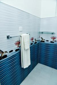 a bathroom with blue and white tiles and towels at Osha Villa in Aluthgama +52 photos