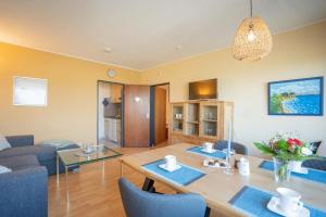a dining room and living room with a table and chairs at Inselblume 11 - Ferienunterkunft am Yachthafen auf Fehmarn in Burgtiefe auf Fehmarn  +7 photos