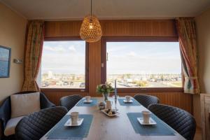 a dining room with a table and chairs and a large window at Inselblume 11 - Ferienunterkunft am Yachthafen auf Fehmarn in Burgtiefe auf Fehmarn 
