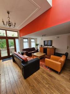 a living room with couches and a table at Groot herenhuis aan zee in Blankenberge