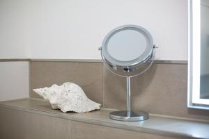 un miroir assis sur un comptoir à côté d'une coquille dans l'établissement Inselblume 18 - Ferienwohnung mit Meerblick & Galerie in der Strandburg, à Burgtiefe auf Fehmarn 