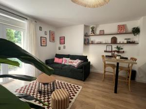 ein Wohnzimmer mit Sofa und Tisch in der Unterkunft Appartement chic & cosy au calme in Albi