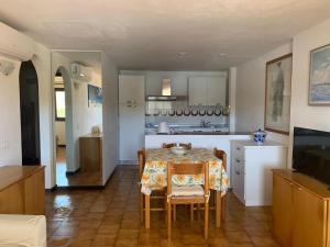 a kitchen and dining room with a table and chairs at Sardegna Beach Cala Reale in Santa Marinella