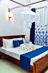 a bedroom with a bed with a blue and white curtain at Osha Villa in Aluthgama