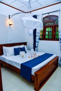 a bedroom with a bed with blue and white sheets at Osha Villa in Aluthgama