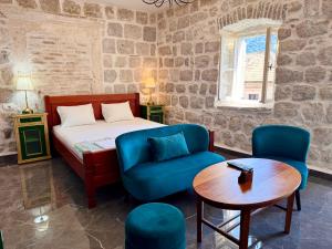 una camera da letto con un letto, due sedie e un tavolo di Guesthouse Žmukić a Perast