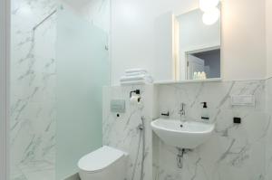 a white bathroom with a toilet and a sink at Petrovdom Apartments 14-1 in RC Diplomat Hall, Zhylianska 59 in Kyiv +19 photos
