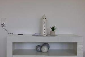 una mensola bianca con un faro sopra di Inselblume 58 - Ferienwohnung mit Balkon in Neue Tiefe a Neue Tiefe Fehmarn