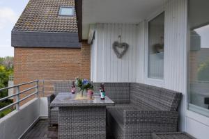 un patio con un tavolo con delle statuette sopra di Inselblume 58 - Ferienwohnung mit Balkon in Neue Tiefe a Neue Tiefe Fehmarn