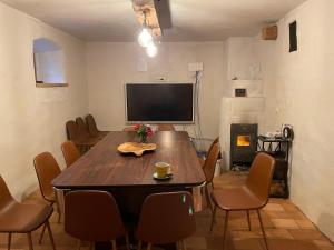a dining room with a table and chairs and a television at Golavškov mlin - Eco Heritage Boutique Stay in Prebold