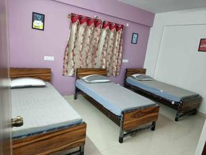 a room with three beds and a curtain at Lakshmi Narasimha Luxury PG for Gents in Bengaluru