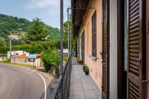a window of a building with a sidewalk next to a road at Casa Lina - Apartment with lake view in Dagnente