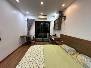 a bedroom with a bed and a table and a desk at An Lạc 402MD in Hanoi