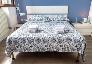 a bed with a blue and white blanket and pillows at Casa Lina - Apartment with lake view in Dagnente