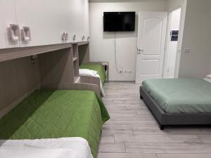 a hotel room with two beds and a flat screen tv at A CASA DI LETY in Tarvisio