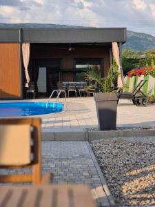 a house with a swimming pool in front of a building at Kuca za odmor B in Kosor