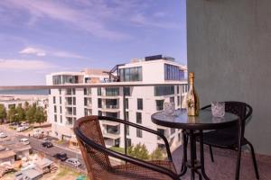 Una botella de vino en una mesa en el balcón de un edificio. en Seraya Summerland, en Mamaia 4 fotos más