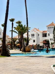 a group of people swimming in a pool with palm trees at Golf y Playa in Roquetas de Mar