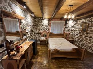 a room with two beds in a room with stone walls at Vechia Villa Mitllari in Tushemisht