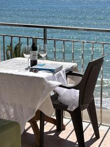 a table with wine glasses on a balcony with the ocean at El crucero, vive unas vacaciones en el mar in Calafell