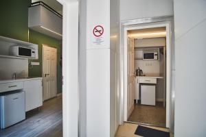 uma cozinha com armários brancos e uma placa de proibido fumar em Z40 - Budget Apartment em Budapeste