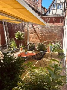 eine Terrasse mit Tisch und Stühlen und einem Sonnenschirm in der Unterkunft sleepArt room for 2 in Celle