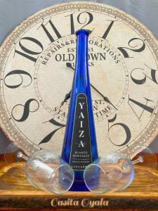 una botella de vino y copas junto a un reloj en Casita Oyala, en San Bartolomé