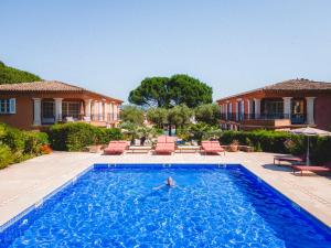 a person swimming in a swimming pool in front of a house at Domaine de l'Astragale in Saint-Tropez