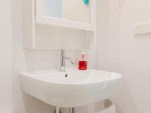 a white sink in a white bathroom with a red soap bottle at Marsalada 2 - Apartment with sea view in Playa de Mar +14 photos