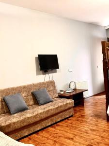 a living room with a couch and a flat screen tv at Nana's Mini Hotel in Tbilisi City