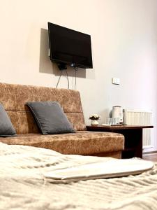a bedroom with a couch and a flat screen tv at Nana's Mini Hotel in Tbilisi City