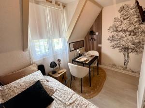 a bedroom with a bed and a table and a desk at Le Ptit Jumoku in Caen
