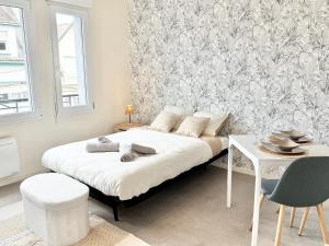 a bedroom with a bed and a table and a wall at Studio clair rivage centre-ville in Lorient