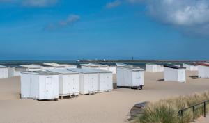 a row of beach huts on a sandy beach at L'Escale in Sangatte