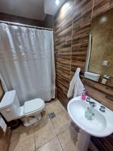 a bathroom with a white toilet and a sink at Farolito de Luz Apart in Salta