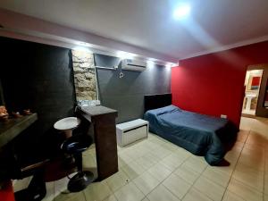 a bedroom with a bed and a red wall at Farolito de Luz Apart in Salta