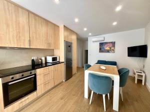 a kitchen with a table and blue chairs in a room at Amadeo Art&Stay Apartments in Amarante +41 photos