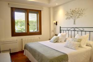 a bedroom with a bed with white sheets and a window at Hotel La Gastrocasa - Adults Only in Gandía +82 photos