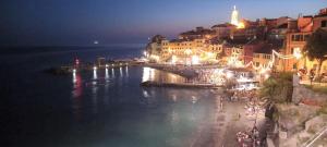 a view of a city at night with the water at Due Finestre Sul Mare in Bogliasco