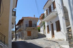 an alley in a town with white buildings at Avlonari Evias flat in the Central Square in Avlonárion