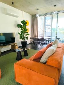 a living room with an orange couch and a television at Bridge House 301-3BR Penthouse in Limassol
