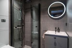 a bathroom with a shower and a sink and a mirror at Riddertunets luksuriøse in Beitostøl +17 photos